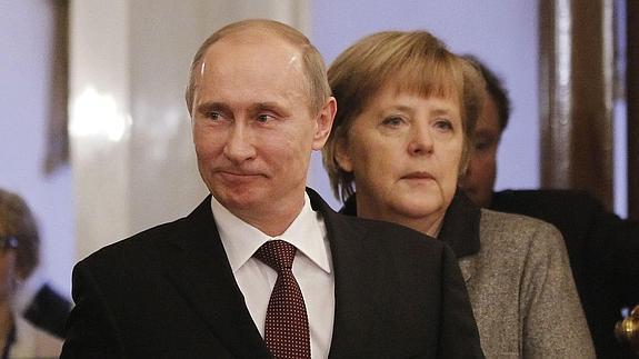 Putin, con Merkel detrás. 