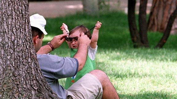 Un padre juega con su hijo en un parque madrileño.