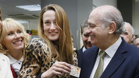 Mireia Belmonte, junto al ministro, muestra su nuevo DNI. 