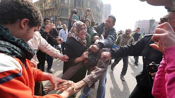 Pelea entre una mujer partidaria del presidente egipcio y un manifestante afecto a Morsi cerca de la Plaza Tahrir.