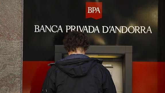 Un hombre sacando dinero de un cajero de BPA. 