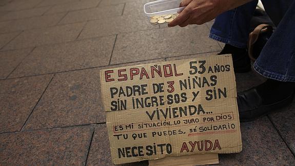 Un indigente pide dinero.