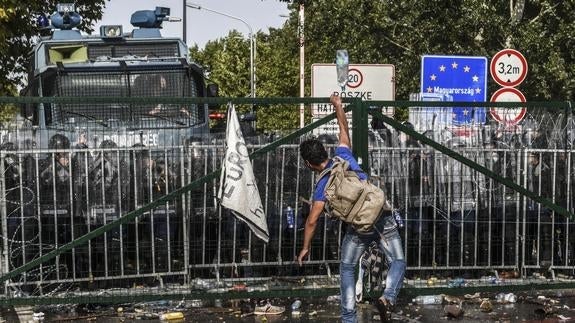 Un refugiado se enfrenta a la Policía húngara.