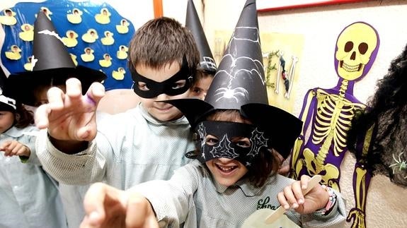 Unos niños intentan asustar por la fiesta de Halloween.