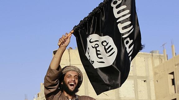 Un miliciano del Estado Islámico ondea una bandera del grupo yihadista.