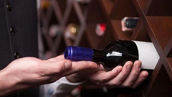 Un sumiller eligiendo una botella de vino 