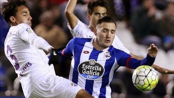 Lucas Pérez (d) lucha por un balón con Weligton. 