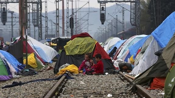 Niños sirios juegan en las vías del tren del campamento de acogida de Idomeni, Grecia.