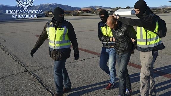 La Policía, trasladando a uno de los detenidos.