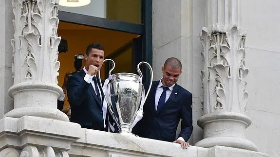 Cristiano Ronaldo (i) y Pepe (d) muestran la Copa de Europa a sus aficionados. 