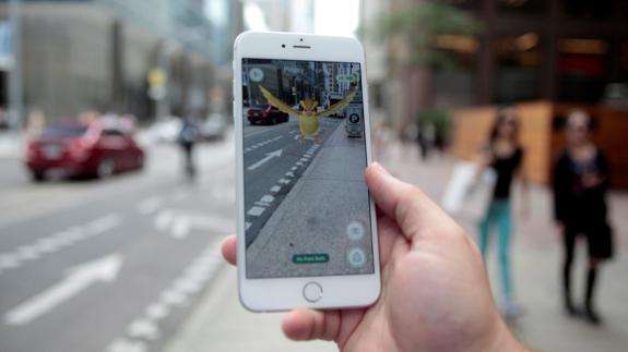 Un hombre juega a Pokémon GO por la calle.