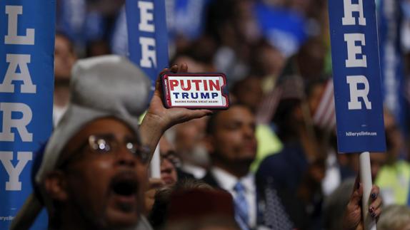Un hombre muestra una imagen de su teléfono móvil que asocia a Putin con Trump durante el último día de la Convención Demócrata. 