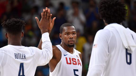 Kevin Durant (centro) da la mano a Jimmy Butler (i). 