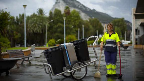 Una trabajadora barriendo las calles de una ciudad.