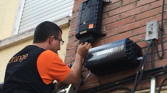 Un técnico instalando fibra óptica en un edificio.