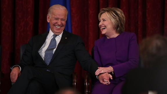 Joseph Biden (i) y Hillary Clinton ríen durante un debate. 