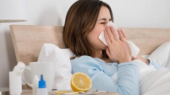 Mujer sufriendo los síntomas de la gripe