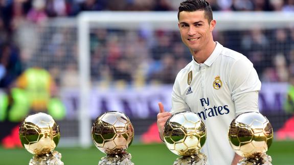 Cristiano, junto a sus cuatro balones de Oro. 