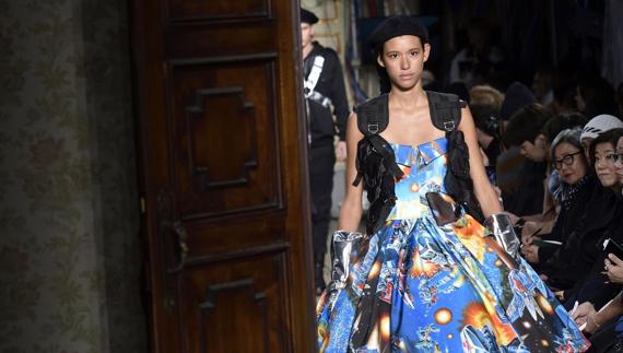 Una modelo precede a un hombre en el desfile de Moschino. 