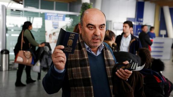 El pasajero Fuad Sharef Suleman muestra su pasaporte después de tener que volver a Iraq desde Egipto.