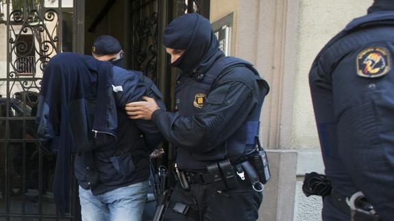 Los Mossos d'Esquadra trasladan a uno de los detenidos.