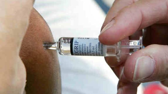 Un médico francés vacuna a un paciente contra la gripe. 