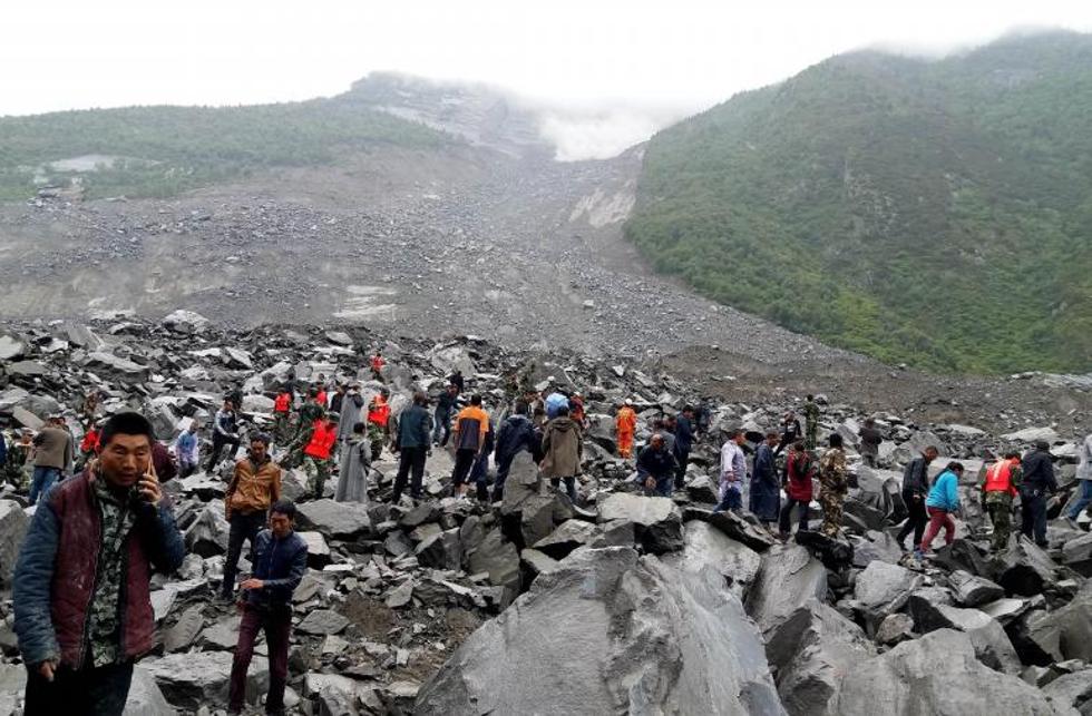 Equipo de rescate y vecinos buscando supervivientes en Maoxian.