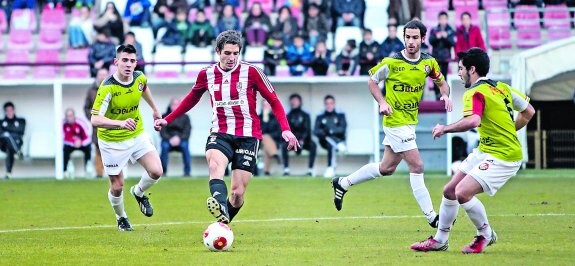 Alain Barrón avanza con el esférico rodeado por tres jugadores de la SD Logroñés, Miguel y Rojas.
