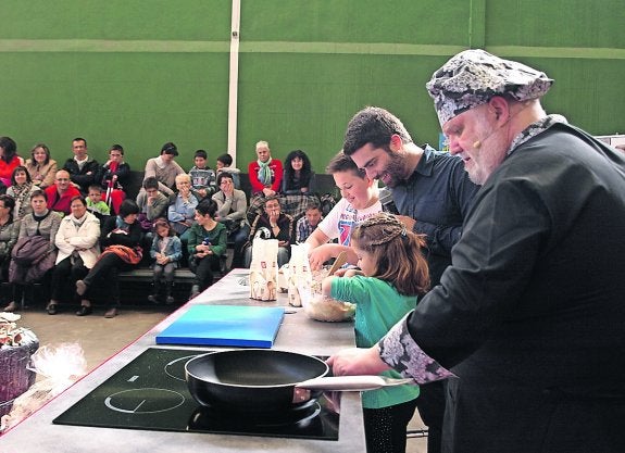 Javier Romero, con las manos en la masa y en el champiñón acompañado de niños.