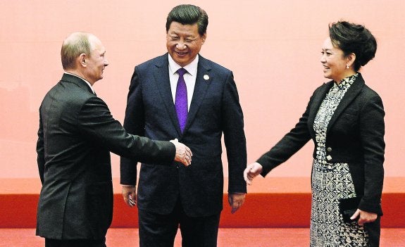 Putin saluda a la primera dama china, Peng Liyuan, ante la mirada del presidente Xi Jinping en la conferencia asiática de Shanghái. 