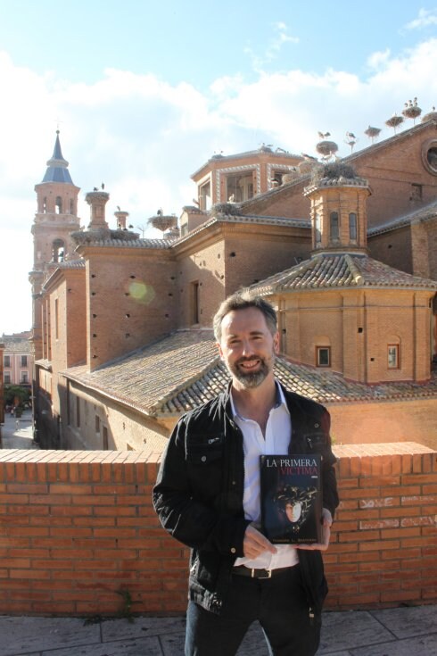 Teo López, con su novela ante la Colegiata de San Miguel. 