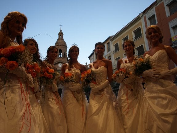 Las damas de las fiestas, la reina saliente y la reina entrante ya con su corona. 