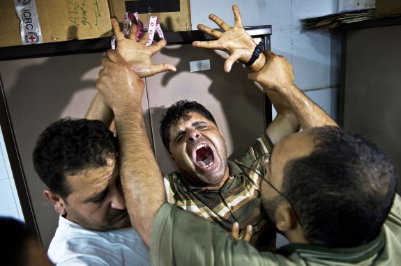 El padre de uno de los tres niños muertos en un bombardeo del Ejército israelí grita en el hospital Al-Shifa de Gaza. 
