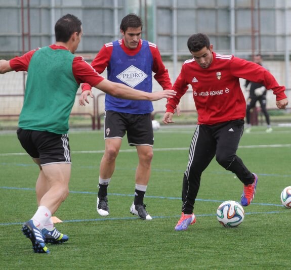 Menudo juega el balón ante Eduardo Ubis y Camochu (i). 