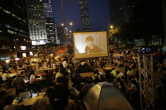Manifestantes prodemocráticos siguen en directo la reunión de ayer con el Gobierno hongkonés en una acampada. 