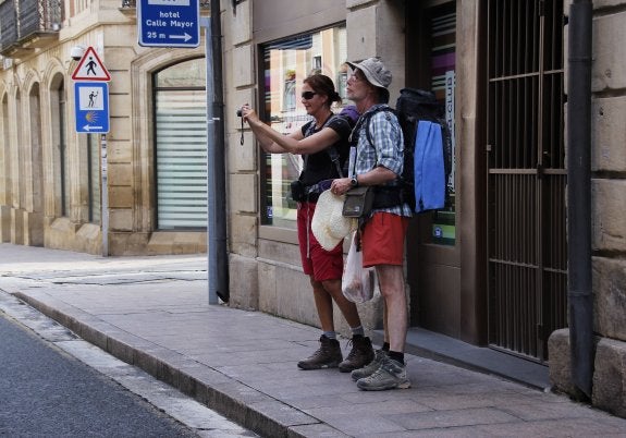 Una pareja de turistas toma fotografías en un tramo del Camino de Santiago a su paso por Logroño. 