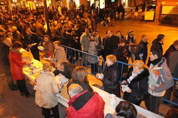 Los arnedanos saborearon las patatas de los Amigos de Arnedo. Arriba, la hoguera de La Chispa y la rondalla del Emboque actuando. 