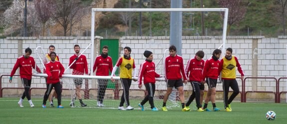 Los jugadores de la UD Logroñés transportan la portería de entrenamientos en unión, la que quieren conseguir para volver a sumar los tres puntos en Las Gaunas esta tarde, después de dos partidos, ante Compostela y Oviedo, sin hacerlo. :: díaz uriel