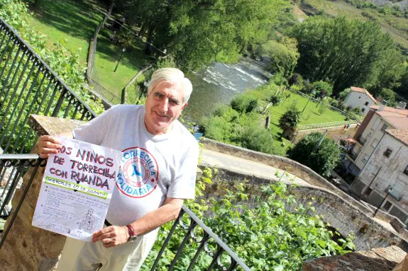 El periodista Enric Sopena posa en Torrecilla en Cameros con el cartel original de la primera Fiesta de la Solidaridad. :: D.M.A.