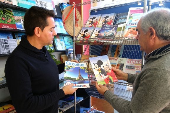 Luis Ángel Vargas (dcha.) muestra folletos promocionales de París. :: JUAN MARín