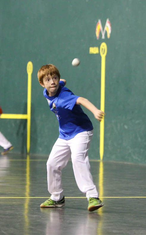 Un joven pelotari se prepara para devolver la pelota en un encuentro del torneo escolar. 