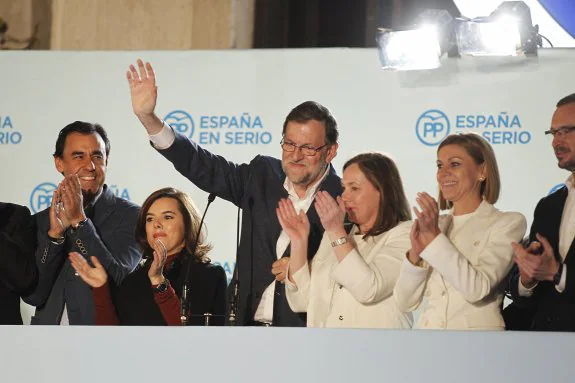 Mariano Rajoy, junto a Soraya Sáenz de Santamaría y María Dolores de Cospedal, saludan desde la sede del PP. :: JOSé RAMóN LADRA