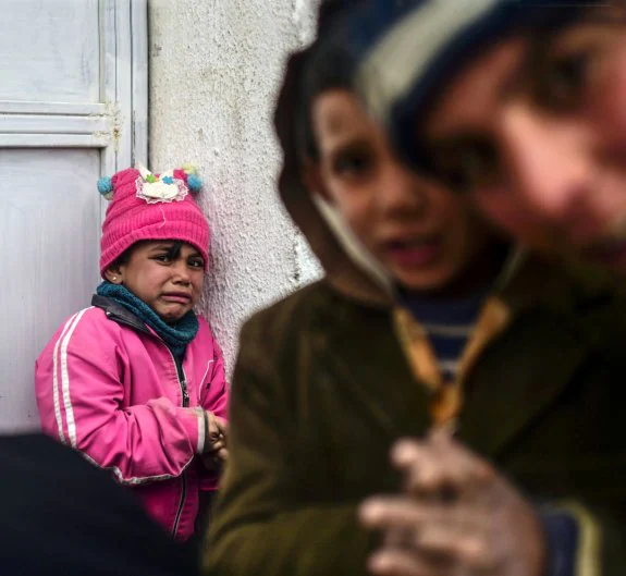 Un niña llora en el paso que conecta Turquía y Siria, un acceso por el que cada día transitan los desplazados que huyen del asedio de Alepo. :: afp