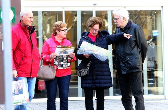 Con el mapa. Cuatro turistas salen de la Oficina de Turismo de Logroño y deciden por dónde comenzar su visita. :: juan marín