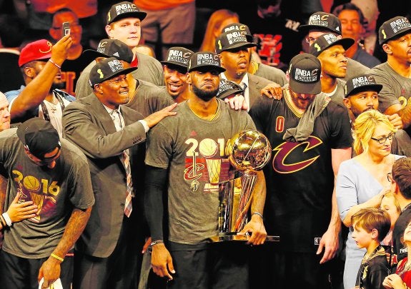 LeBron James sujeta el trofeo de campeón de la NBA rodeado de sus compañeros y técnicos. :: afp
