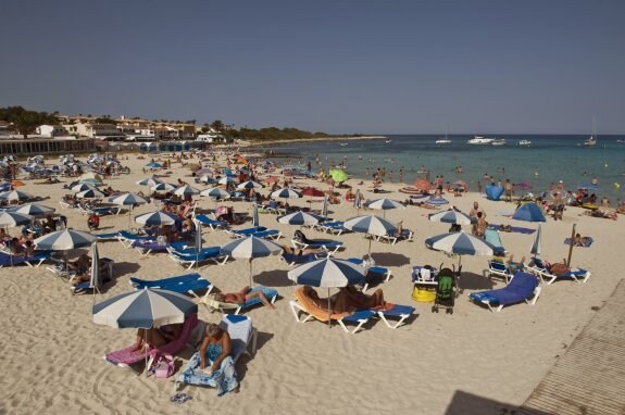 Turistas en la playa de Punta Prima (Menorca). :: efe