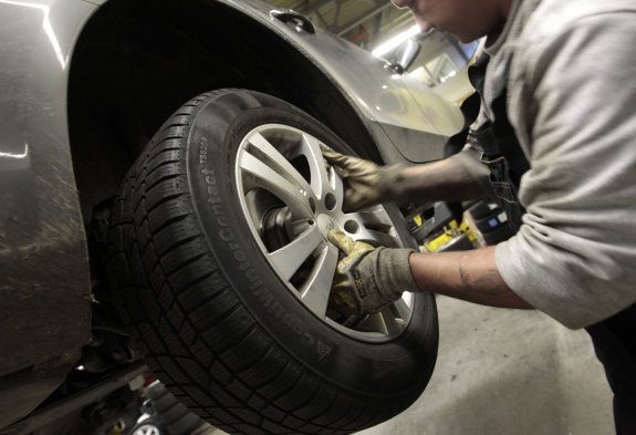 Cambio. Un especialista sustituye un neumático en un vehículo. :: L.R.M.