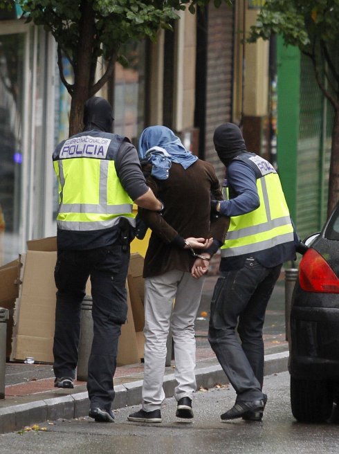Policías custodian a un detenido durante una operación antiyihadista en Madrid . :: victor lerena / EFE