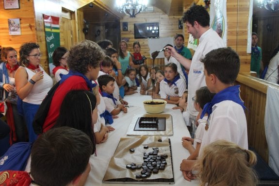 Un cocinero explica a los niños la manipulación del chocolate. 