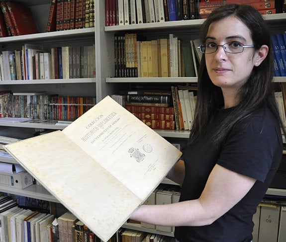 Una mujer muestra un volumen en la biblioteca de la sede de la Fundación Gustavo Bueno en Oviedo. :: j. d.